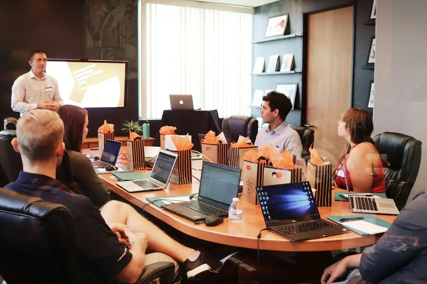 A presenter leading a meeting around a table